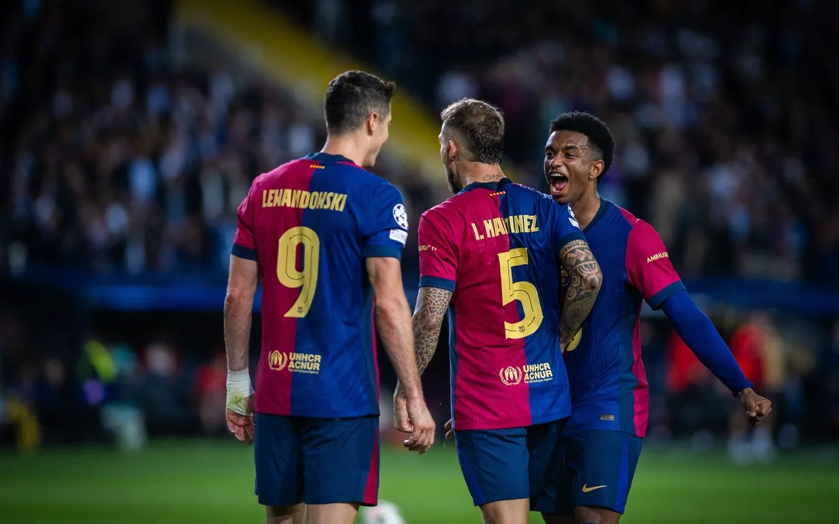 Pemain sepak bola merayakan gol di lapangan dengan seragam merah biru
