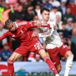 Pemain Liverpool dan Arsenal berebut bola dalam pertandingan Liga Premier.